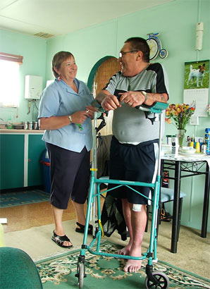 Woman assisting a man with his walker